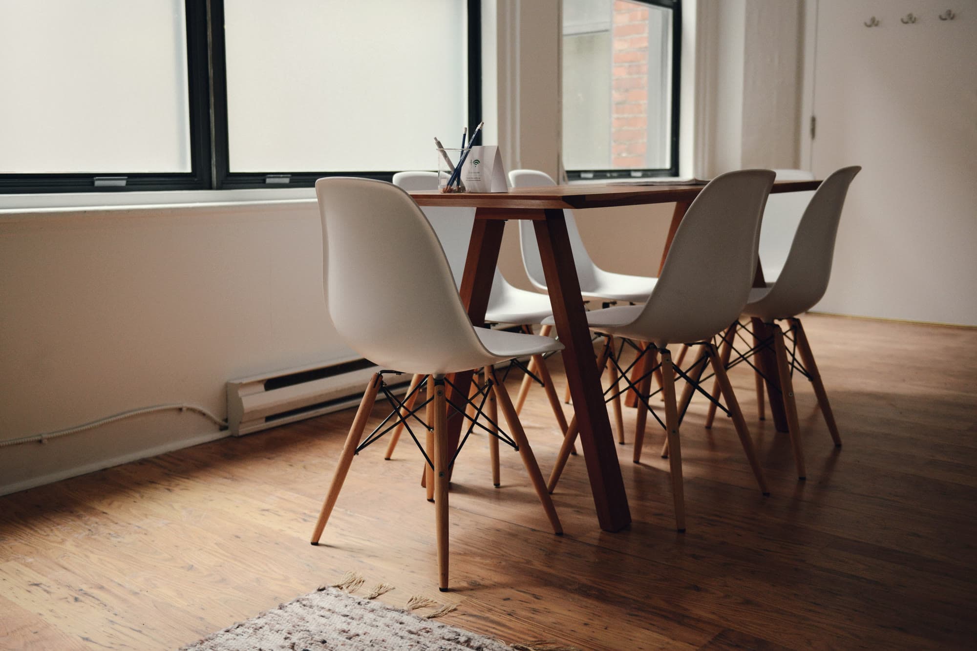 A small bright office with a wooden table and big windows